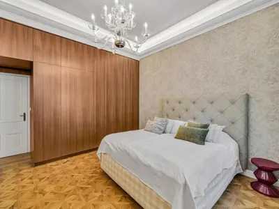 a bedroom with a large bed and a chandelier at Romantic Apartman by Prague Castle in Prague