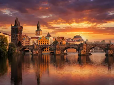a bridge over a river with a city in the background at Romantic Apartman by Prague Castle in Prague