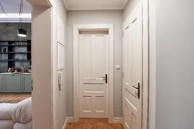 a hallway with a white door and a kitchen at Romantic Apartman by Prague Castle in Prague