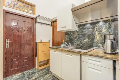 a kitchen with white cabinets and a wooden door at 3BR Apartment in Old Town - Self Check-in - Prague 1 - Sleep up to 8 in Prague