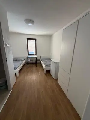 a room with two beds and a table in it at Ubytování TJ Sokol Kostelec nad Černými lesy in Kostelec nad Černými Lesy