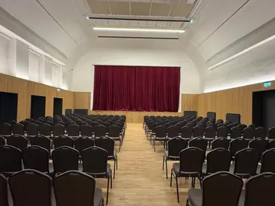 a large room with chairs and a red curtain at Ubytování TJ Sokol Kostelec nad Černými lesy in Kostelec nad Černými Lesy