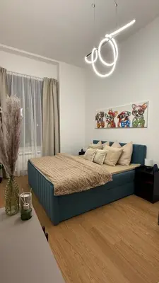 a bedroom with a blue bed in a white room at Vinohrady 105 - Prestige in Prague