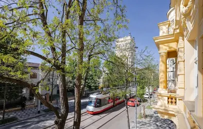 a train on a street next to a building at Vinohrady 105 - Prestige in Prague