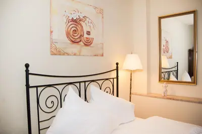 a bedroom with a bed with white sheets and a mirror at Just For Two Ruterra Studio in Prague