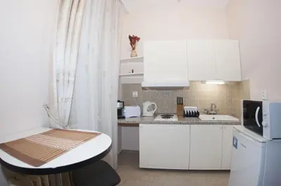 a kitchen with white cabinets and a sink and a microwave at Just For Two Ruterra Studio in Prague