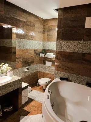 a bathroom with a tub and a toilet and a sink at Apartment Lupáčova in Prague