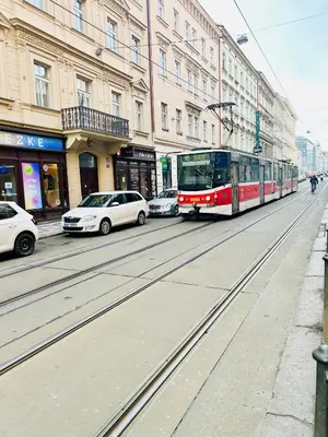 a bus is driving down a city street with cars at Lidická 31 Apartment Prague ,2 Bedrooms ,8 Guests ,Near Center in Prague
