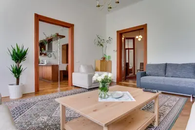a living room with a table and a blue couch at Charming 2BR Garden Views in Historic Vinohrady in Prague