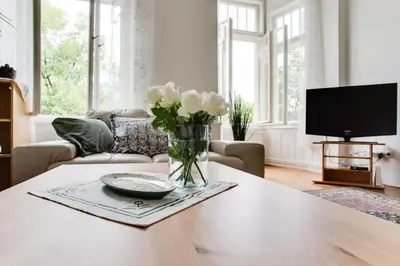 a living room with a vase of flowers on a table at Charming 2BR Garden Views in Historic Vinohrady in Prague