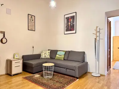 a living room with a gray couch and a table at Spacious 2BR in Historical Vinohrady in Prague