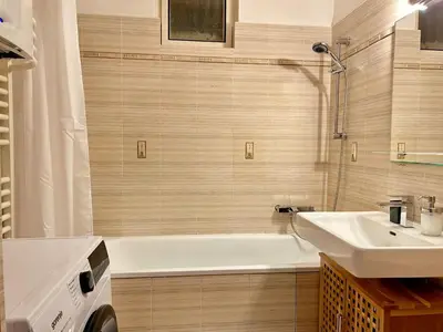 a bathroom with a white tub and a sink at Spacious 2BR in Historical Vinohrady in Prague
