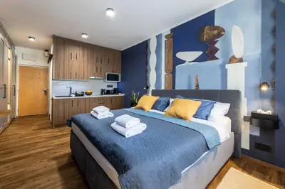 a bedroom with a blue bed with towels on it at Prague Castle View by Charles Bridge in Prague