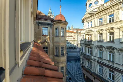 a view from a window of a city street with buildings at Prague Castle View by Charles Bridge in Prague