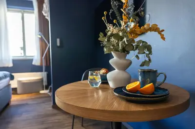 a wooden table with a vase and oranges on it at Prague Castle View by Charles Bridge in Prague