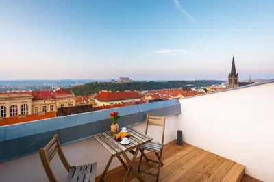 a balcony with a table and chairs and a view of a city at Old Prague View Rooftop Studio with AC in Prague