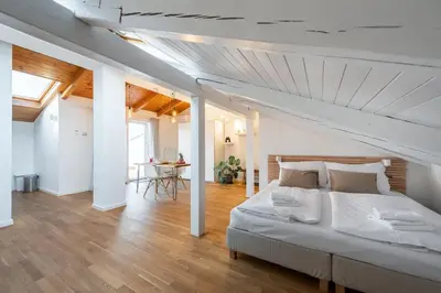 a bedroom with a large bed and a dining room at Old Prague View Rooftop Studio with AC in Prague