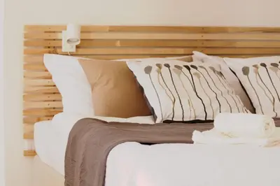 a bed with white pillows and a wooden headboard at Old Prague View Rooftop Studio with AC in Prague