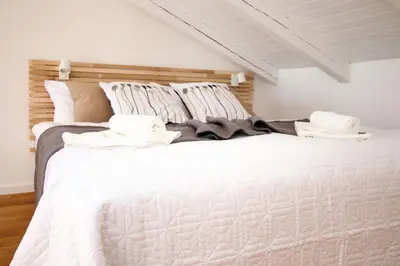 a white bed with two towels on top of it at Old Prague View Rooftop Studio with AC in Prague