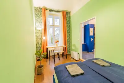 a room with a bed and a table and a window at Luna Female Hostel in Prague