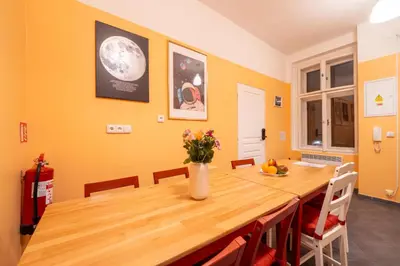 a dining room with a wooden table and chairs at Luna Female Hostel in Prague