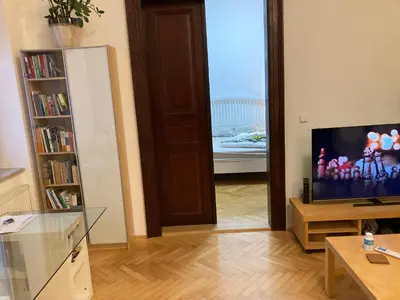 a living room with a television and a room with a bed at Wenceslas Square Center in Prague