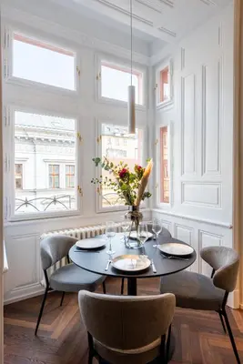 a dining room with a table and chairs and windows at High-End Apartments with AC Steps from Wenceslas Square by EasyBNB Premium in Prague