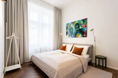a bedroom with a bed and a painting on the wall at High-End Apartments with AC Steps from Wenceslas Square by EasyBNB Premium in Prague