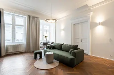 a living room with a green couch and a table at High-End Apartments with AC Steps from Wenceslas Square by EasyBNB Premium in Prague