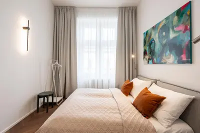 a bedroom with a bed and a painting on the wall at High-End Apartments with AC Steps from Wenceslas Square by EasyBNB Premium in Prague