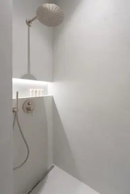 a white bathroom with a shower with a shower head at High-End Apartments with AC Steps from Wenceslas Square by EasyBNB Premium in Prague