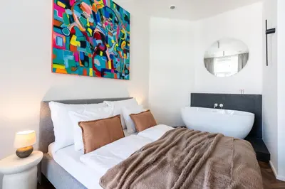 a bedroom with a large bed and a bath tub at High-End Apartments with AC Steps from Wenceslas Square by EasyBNB Premium in Prague