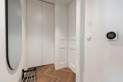 a hallway with a mirror and a closet with wooden floors at High-End Apartments with AC Steps from Wenceslas Square by EasyBNB Premium in Prague