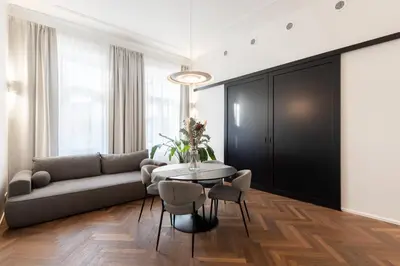 a living room with a couch and a table and chairs at High-End Apartments with AC Steps from Wenceslas Square by EasyBNB Premium in Prague