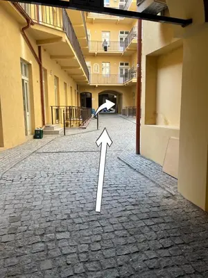 an empty hallway with an arrow pointing to a building at Amber Nest in the Heart of Prague in Prague
