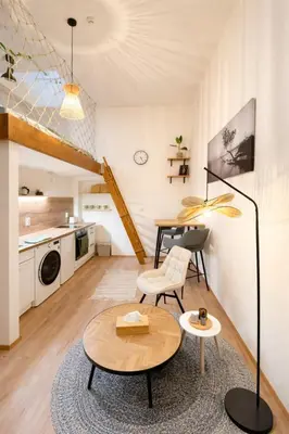 a living room with a table and chairs and a kitchen at Garden Studio in Prague