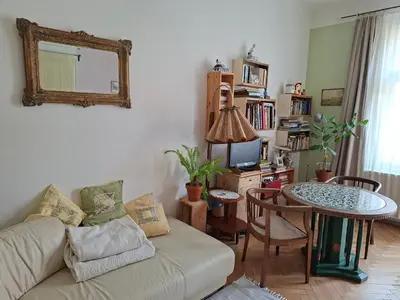 a living room with a couch and a table with a mirror at Cosy place in Prague 2 Vinohrady in Prague