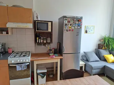 a kitchen with a stainless steel refrigerator and a couch at Cosy place in Prague 2 Vinohrady in Prague