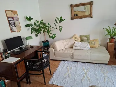 a living room with a couch and a desk with a computer at Cosy place in Prague 2 Vinohrady in Prague