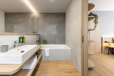 a bathroom with a white sink and a tub at Malleta Living in Prague