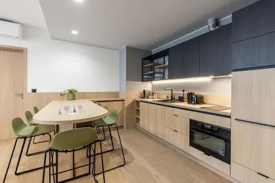 a kitchen with a table and green chairs at Malleta Living in Prague