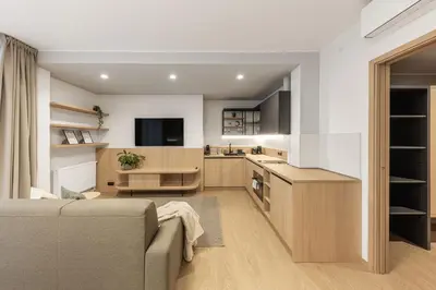 a living room with a couch and a kitchen at Malleta Living in Prague