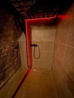 a bathroom with a shower with a red light at Playroom Prague Karlín in Prague