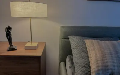 a bedroom with a lamp on a table next to a bed at Viktorka in Prague
