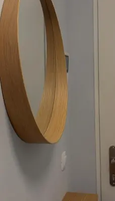 a wooden mirror on a wall in a bathroom at Viktorka in Prague