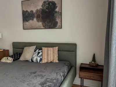 a bedroom with a green couch with pillows on it at Viktorka in Prague