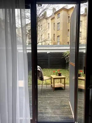 a sliding glass door to a patio with a table at Garden studio in the heart of Vinohrady in Prague