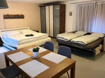 a room with two beds and a table and chairs at Garden studio in the heart of Vinohrady in Prague