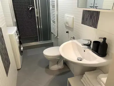 a white bathroom with a toilet and a sink at Garden studio in the heart of Vinohrady in Prague