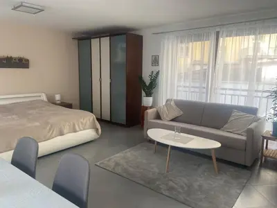 a bedroom with a bed and a couch and a table at Garden studio in the heart of Vinohrady in Prague